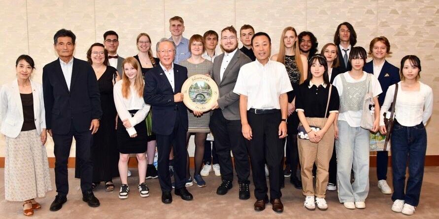 12 junge Menschen besuchten Japan und stellten sich zum Gruppenfoto mit den Gastgebern