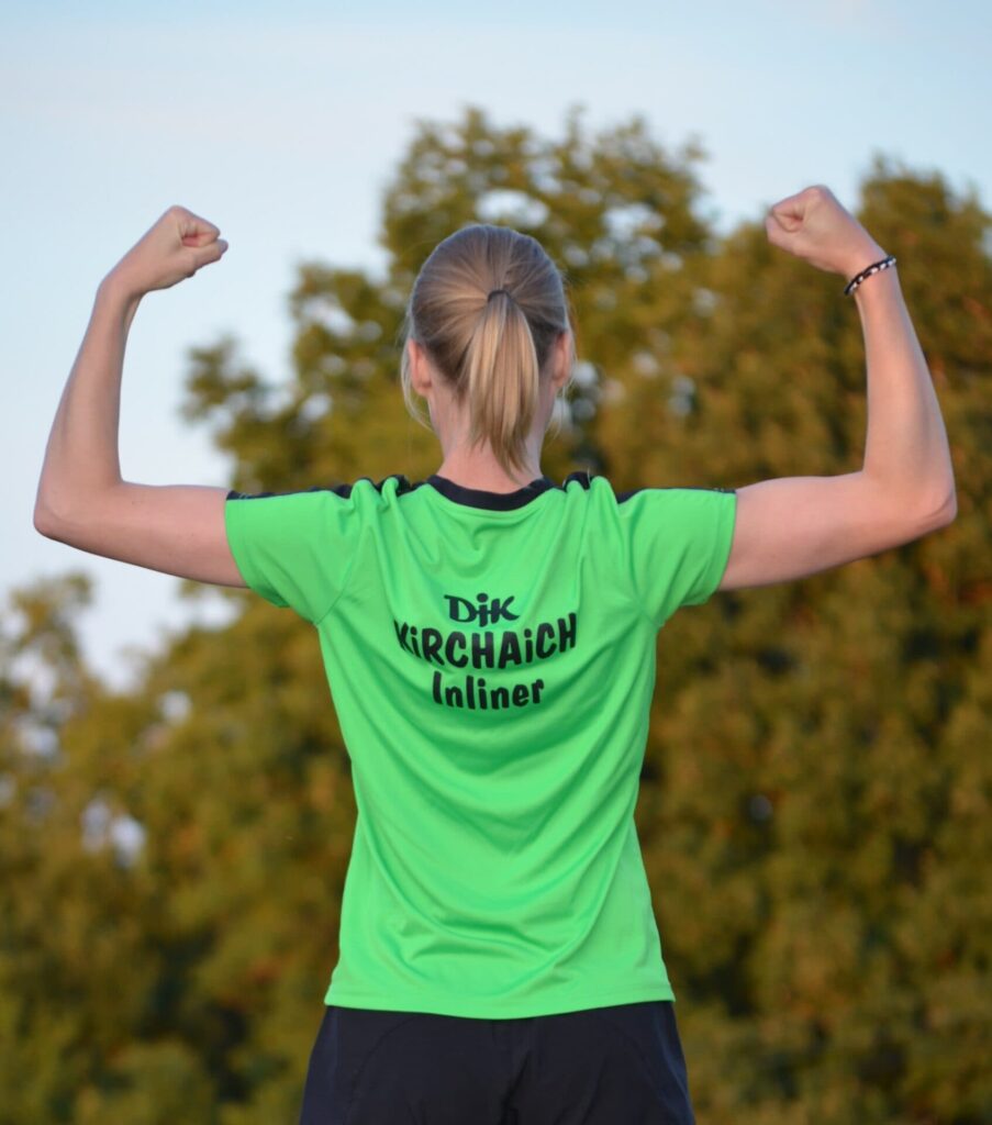 Frau im grünen Trikot von hinten mit Aufschrift DJK Kirchhain
