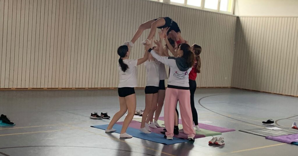 Eine Gruppe Mädchen, die eine akrobatische Figur üben