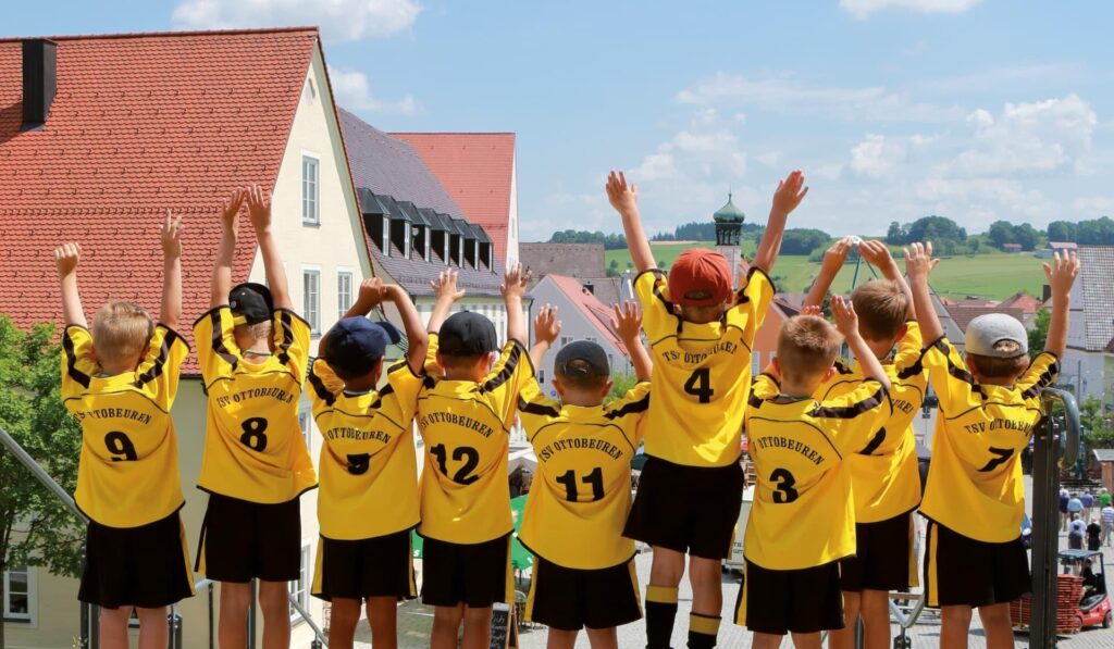 Kindergruppe vom TSV Ottobeuren jubelnd von hinten in gelben Vereinstrikots